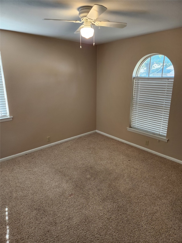 spare room featuring carpet flooring and ceiling fan