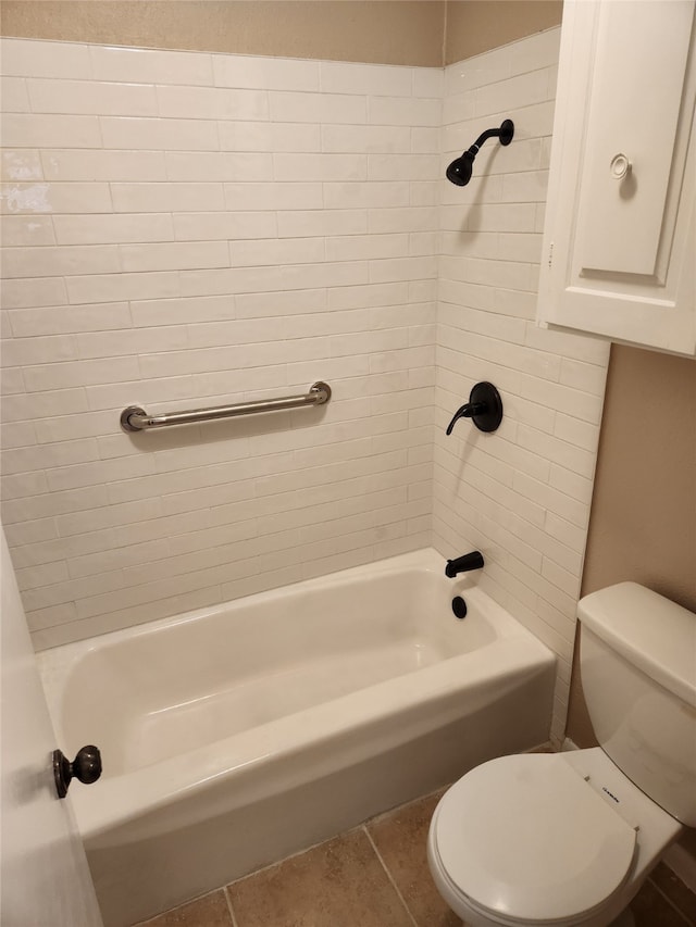 bathroom featuring tiled shower / bath, tile patterned floors, and toilet