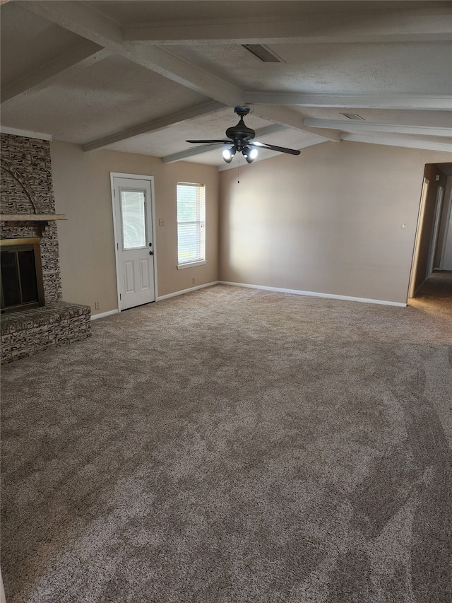 unfurnished living room with ceiling fan, a brick fireplace, a textured ceiling, lofted ceiling with beams, and carpet floors