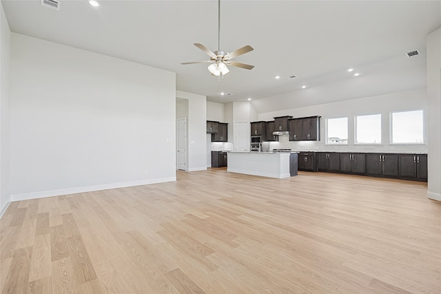 kitchen with ceiling fan, a center island with sink, and light hardwood / wood-style floors