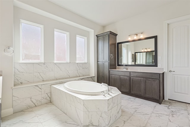 bathroom with vanity and tiled tub