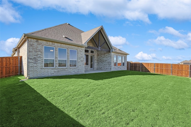 rear view of house with a yard and a patio