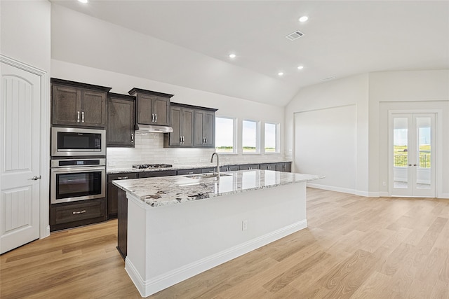 kitchen with sink, stainless steel appliances, vaulted ceiling, and light hardwood / wood-style flooring