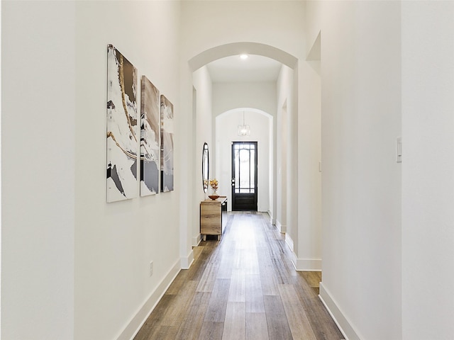 corridor with a high ceiling and wood-type flooring