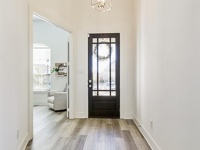 foyer entrance featuring a chandelier and light wood-type flooring