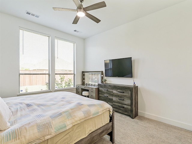 carpeted bedroom with ceiling fan and multiple windows