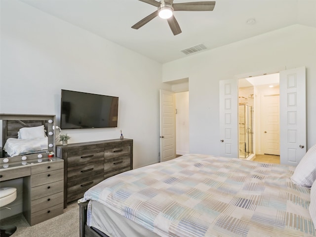 bedroom featuring light carpet, ceiling fan, ensuite bathroom, and vaulted ceiling