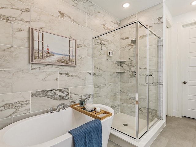 bathroom featuring plus walk in shower and tile walls