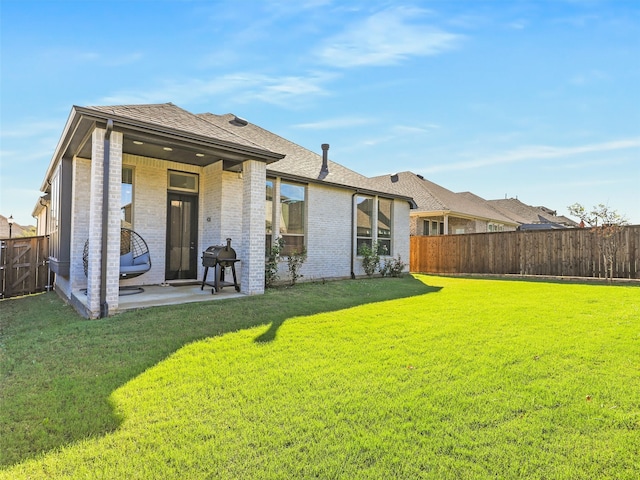 rear view of house with a yard and a patio