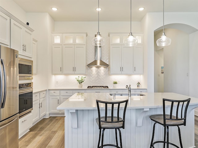 kitchen with a kitchen island with sink, appliances with stainless steel finishes, sink, and white cabinetry