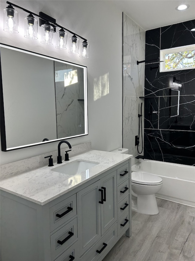 full bathroom with vanity, tiled shower / bath combo, toilet, and plenty of natural light