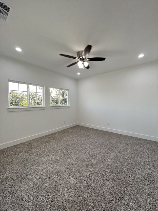 spare room featuring a wealth of natural light, carpet, and ceiling fan