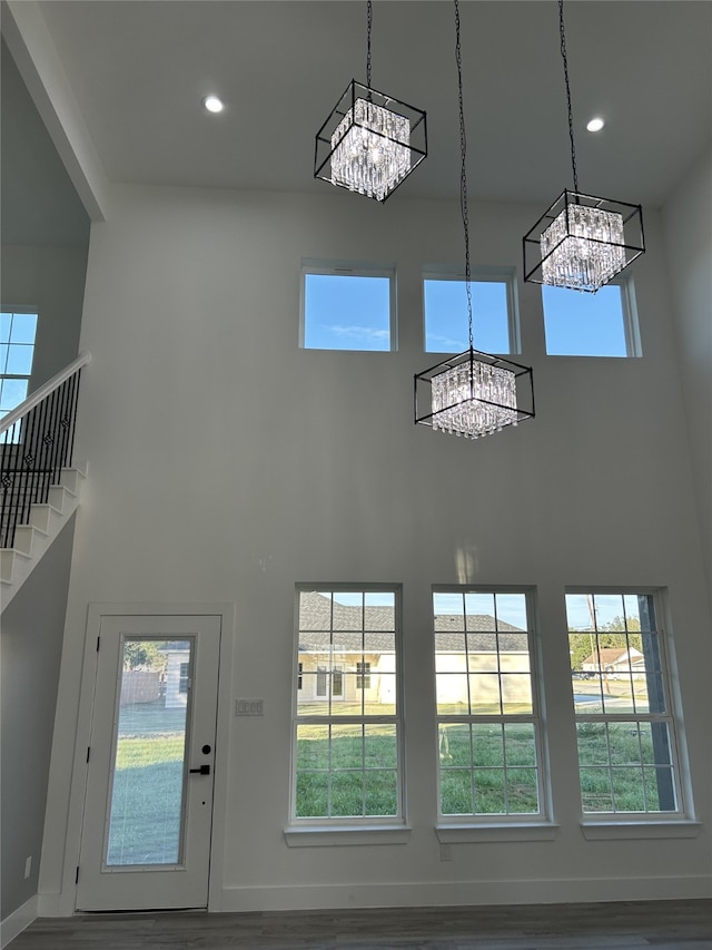 staircase featuring hardwood / wood-style flooring and a towering ceiling