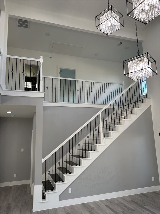 entryway with a towering ceiling, an inviting chandelier, and dark hardwood / wood-style floors