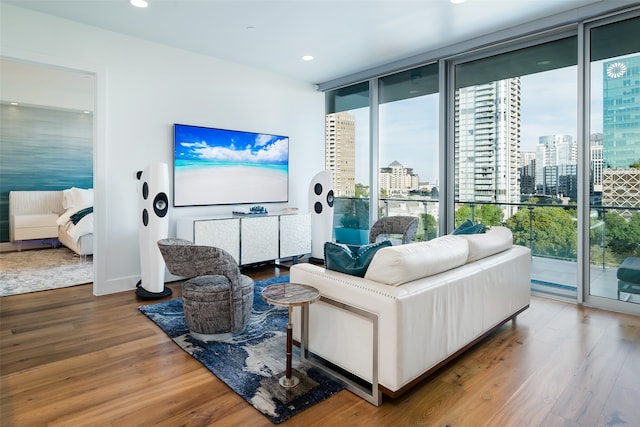 living room with expansive windows, hardwood / wood-style flooring, and a wealth of natural light