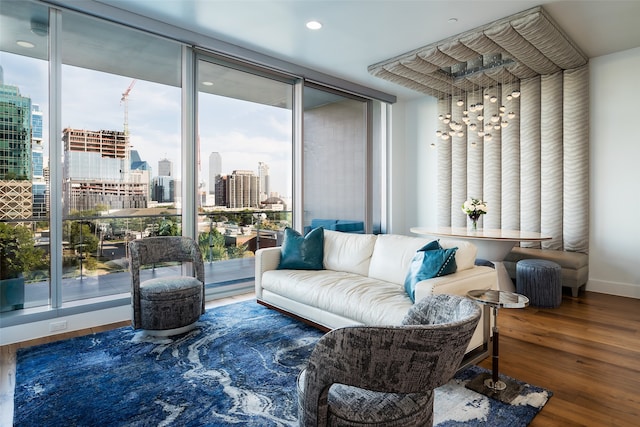 living area with wood-type flooring, expansive windows, and plenty of natural light