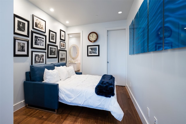 bedroom with connected bathroom and dark wood-type flooring