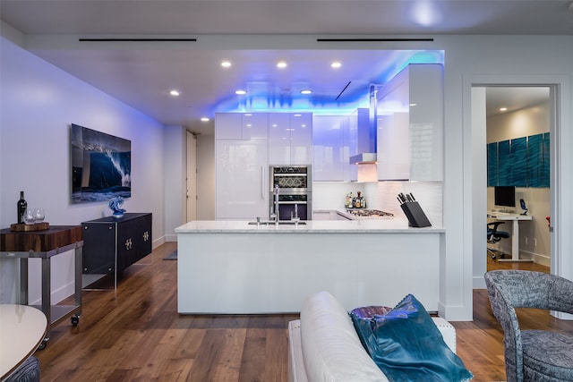 kitchen with sink, stainless steel double oven, dark hardwood / wood-style flooring, and white cabinetry