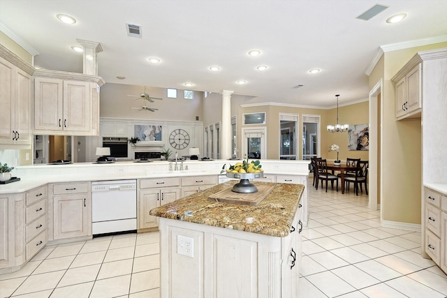 kitchen with ceiling fan with notable chandelier, decorative columns, kitchen peninsula, a kitchen island, and white dishwasher