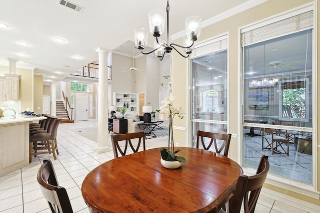 dining area with ornate columns, ornamental molding, ceiling fan with notable chandelier, and light tile patterned floors