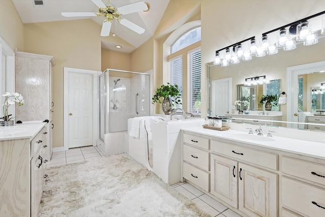 bathroom with plus walk in shower, high vaulted ceiling, tile patterned floors, ceiling fan, and vanity