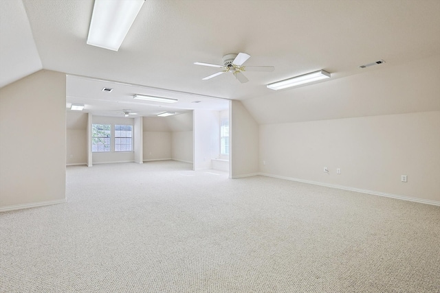 additional living space with vaulted ceiling, ceiling fan, and light colored carpet