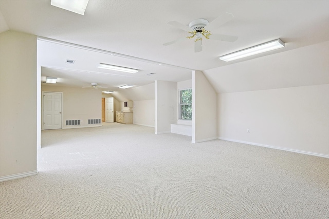 additional living space with light carpet, vaulted ceiling, and ceiling fan