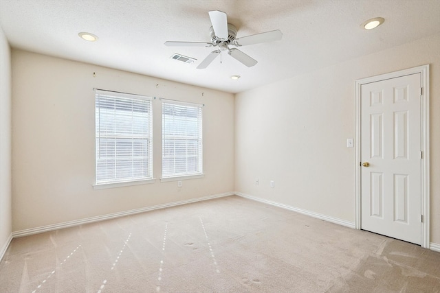 spare room featuring ceiling fan and light colored carpet