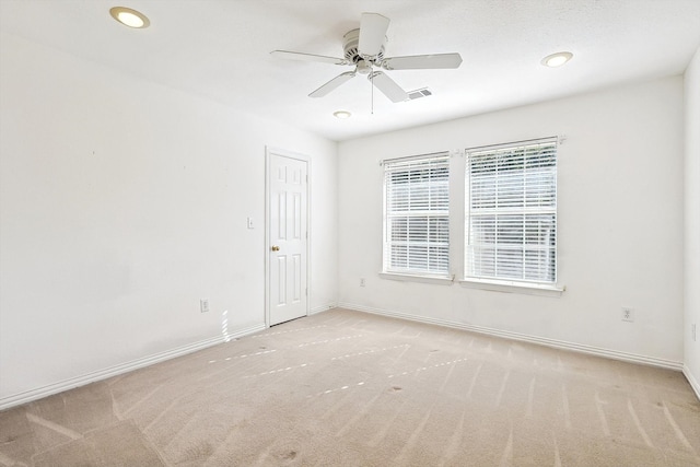 carpeted spare room featuring ceiling fan