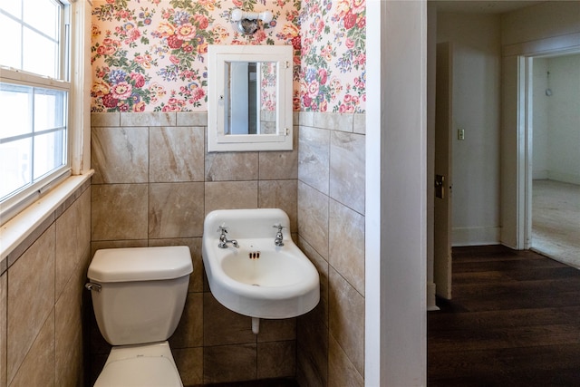 bathroom with toilet, tile walls, sink, and hardwood / wood-style flooring