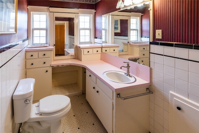 bathroom with vanity, tile patterned flooring, toilet, and tile walls