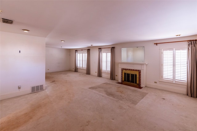 unfurnished living room featuring light carpet and a brick fireplace