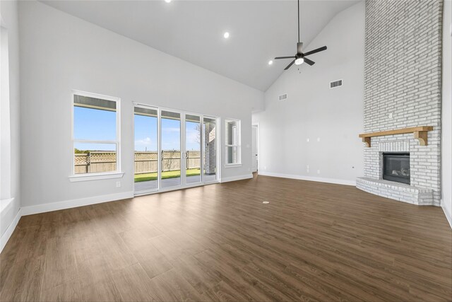 unfurnished living room featuring a fireplace, dark hardwood / wood-style floors, high vaulted ceiling, and ceiling fan