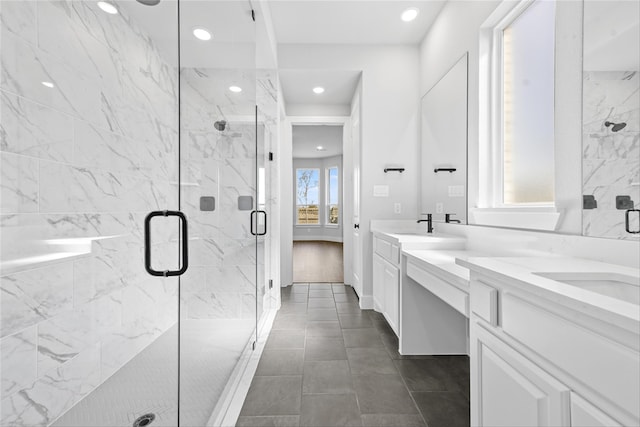 bathroom featuring tile patterned floors, a wealth of natural light, a shower with door, and vanity