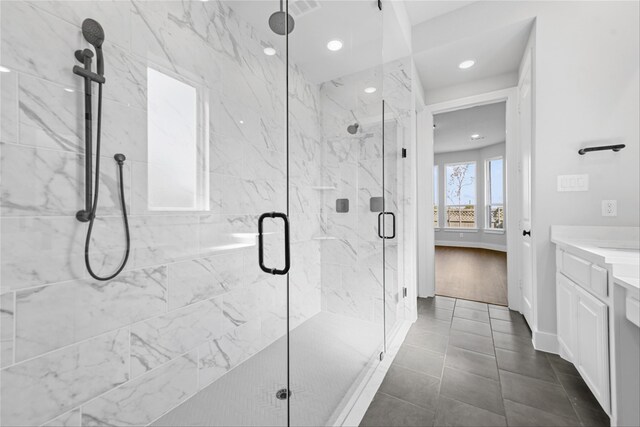 bathroom featuring tile patterned floors, vanity, and a shower with door