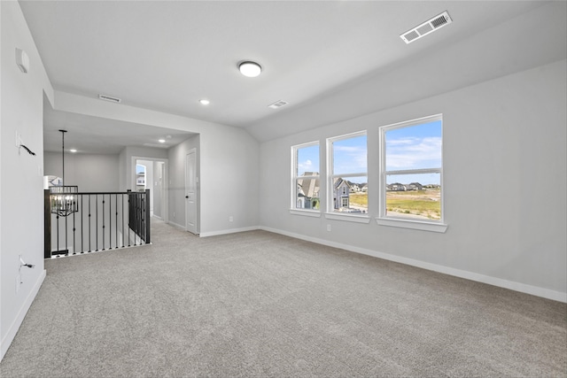 carpeted spare room with a notable chandelier