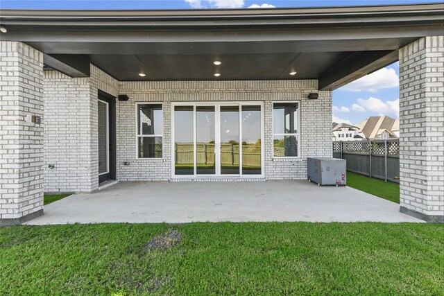 back of house with a patio area and a yard