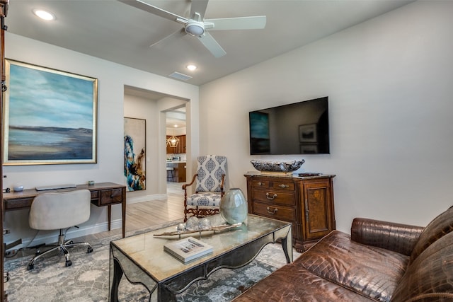 living room with light hardwood / wood-style flooring and ceiling fan