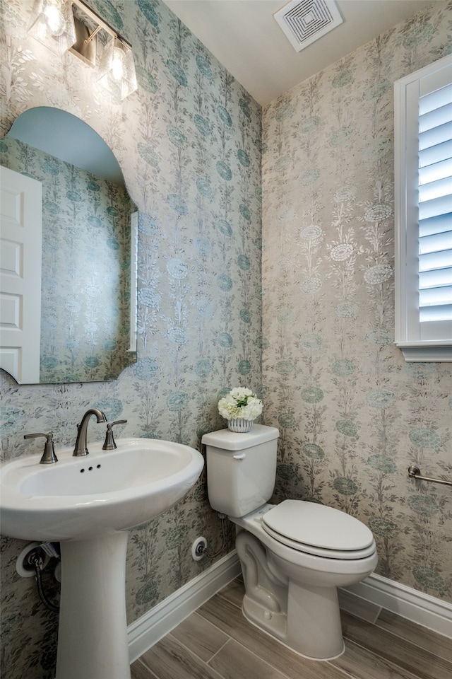 bathroom with toilet and wood-type flooring