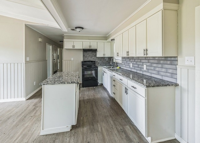 kitchen featuring wood-type flooring, dark stone countertops, black range, and a kitchen island