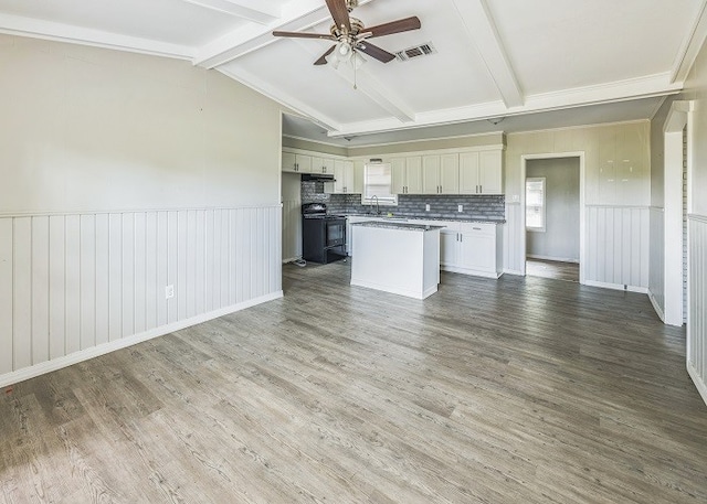 kitchen with hardwood / wood-style flooring, electric range, tasteful backsplash, white cabinetry, and a kitchen island