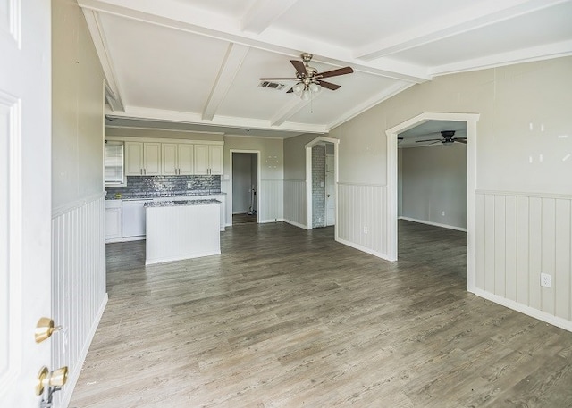 unfurnished living room featuring ornamental molding, wood-type flooring, beam ceiling, and ceiling fan