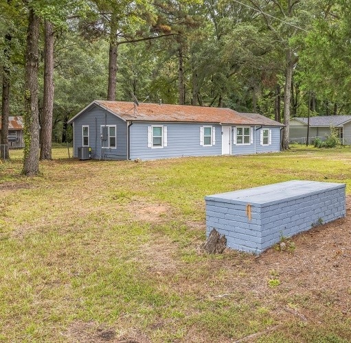 exterior space featuring a front lawn and central air condition unit