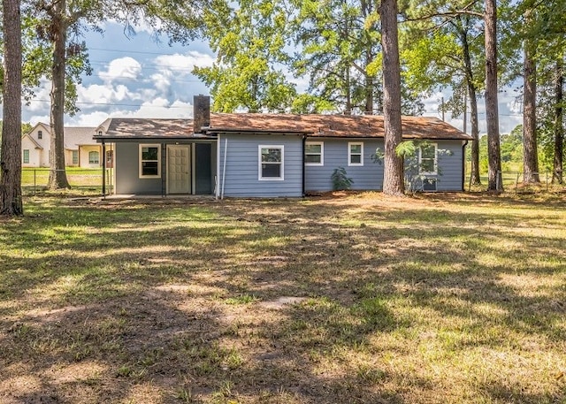 rear view of house featuring a patio area and a yard