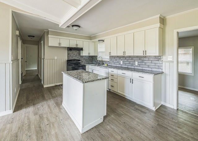 kitchen with white cabinetry, light hardwood / wood-style floors, a center island, and black electric range