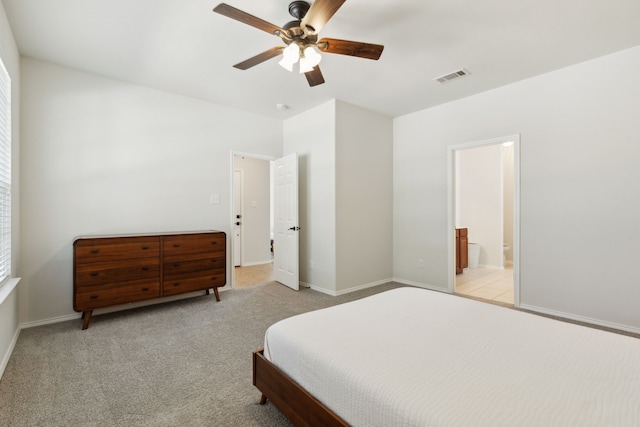 carpeted bedroom featuring ceiling fan and ensuite bath