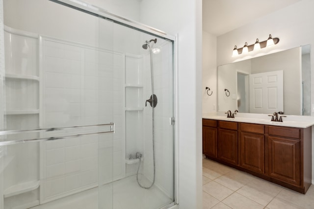 bathroom with tile patterned floors, walk in shower, and vanity