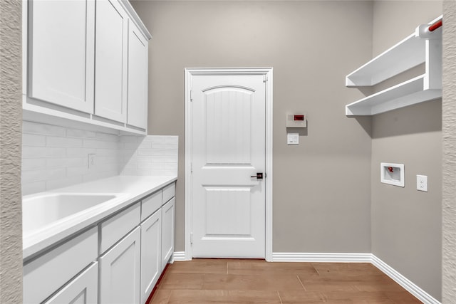 laundry room featuring washer hookup, light hardwood / wood-style floors, and cabinets