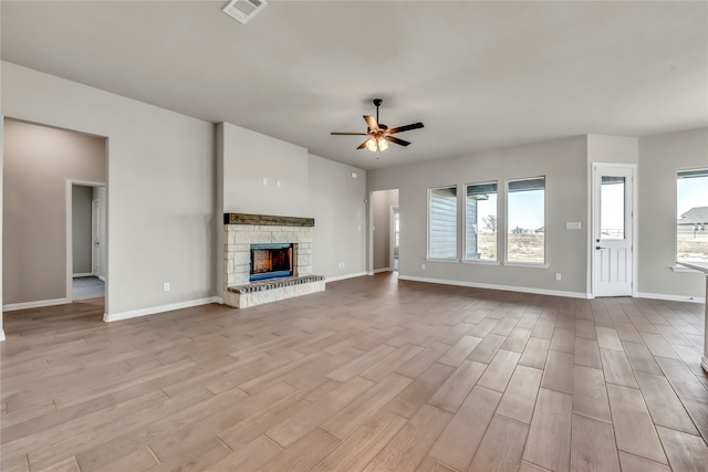 unfurnished living room featuring a fireplace, light hardwood / wood-style flooring, ceiling fan, and a healthy amount of sunlight