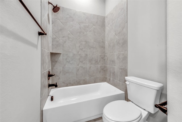 bathroom featuring toilet and tiled shower / bath